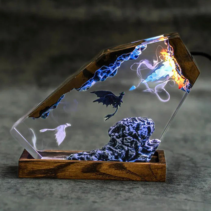 Side view of the dragon resin lamp glowing with orange fire and blue ice at the top edge