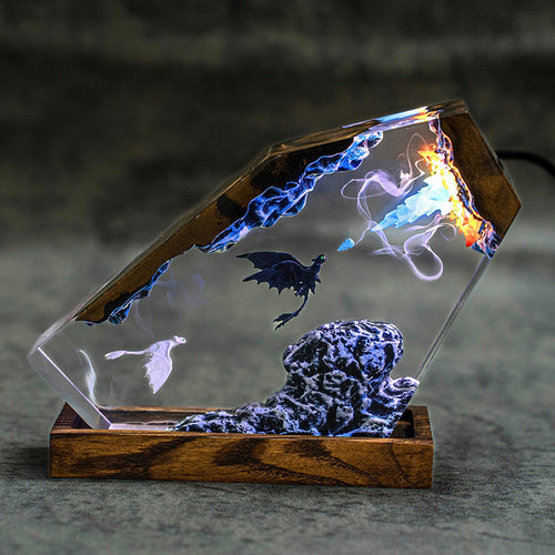Fire & Frost Dragon Resin Lamp lit in a dark room, black and white dragons in clear resin on a wood base