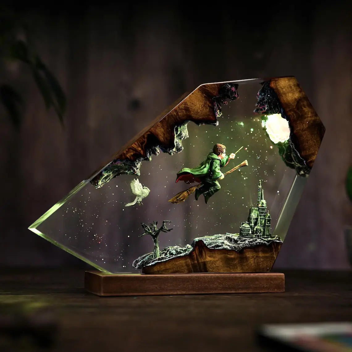 Broomstick Flight resin lamp lit in a dark room